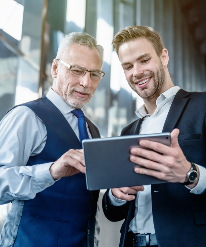 Business partners work together on a tablet. Business partners work together on a tablet.