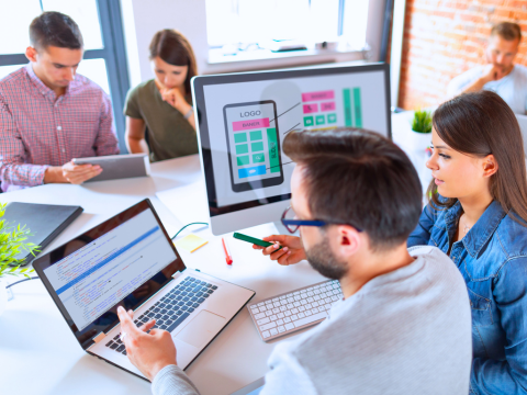 A team of website designers collaborates on site layout and coding.