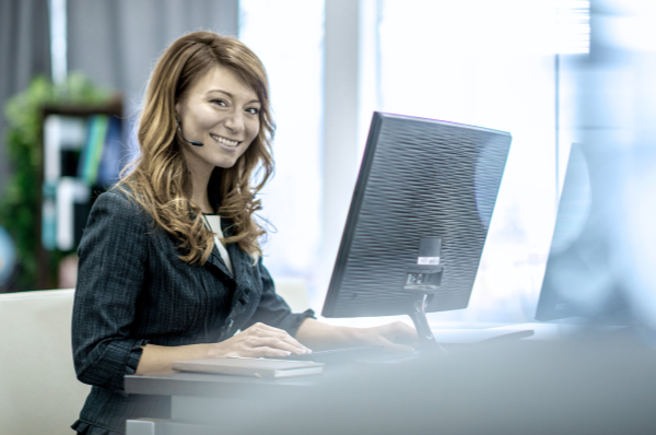 Asian women with headset sitting in front of monitor