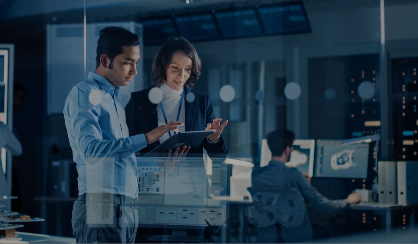 Colleagues look together at a tablet in a technology facility