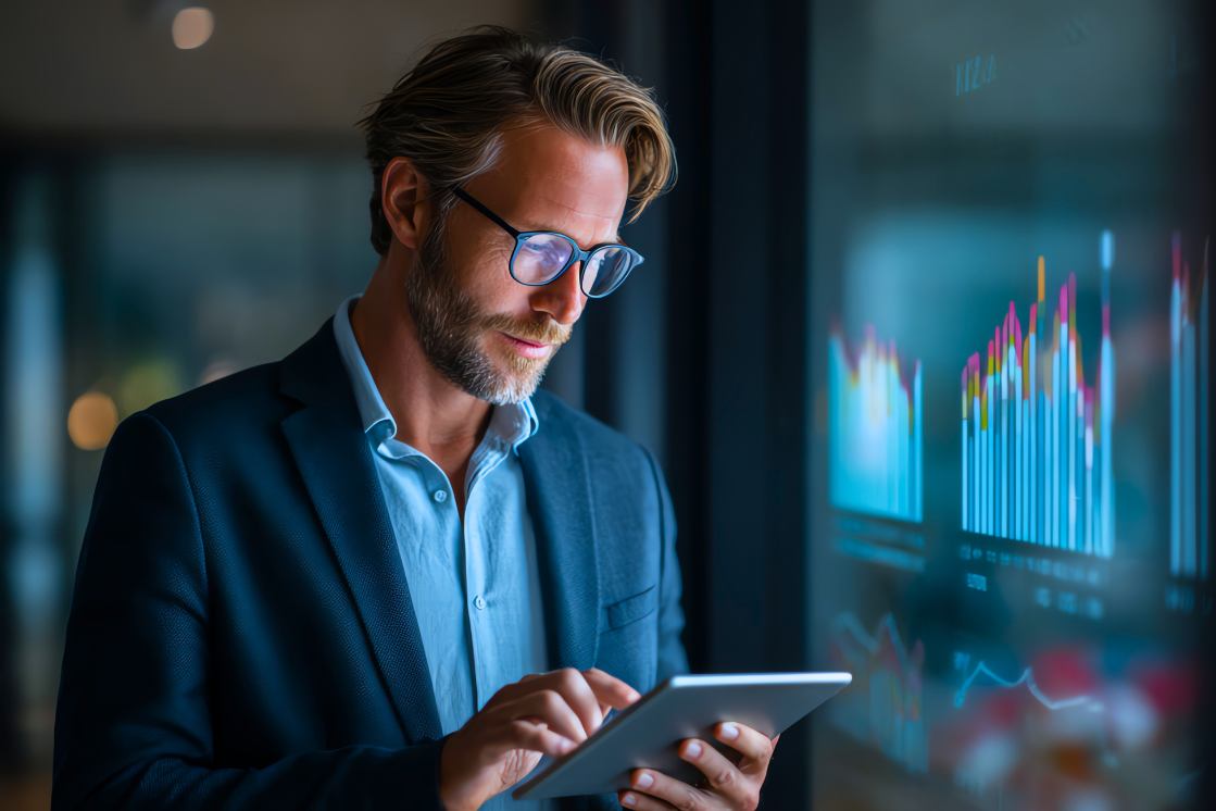 A business professional looks at analytics on a tablet. A business professional looks at analytics on a tablet.