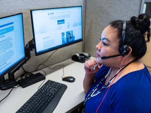 A remote technician reads her monitor as she provides remote assistance and support.