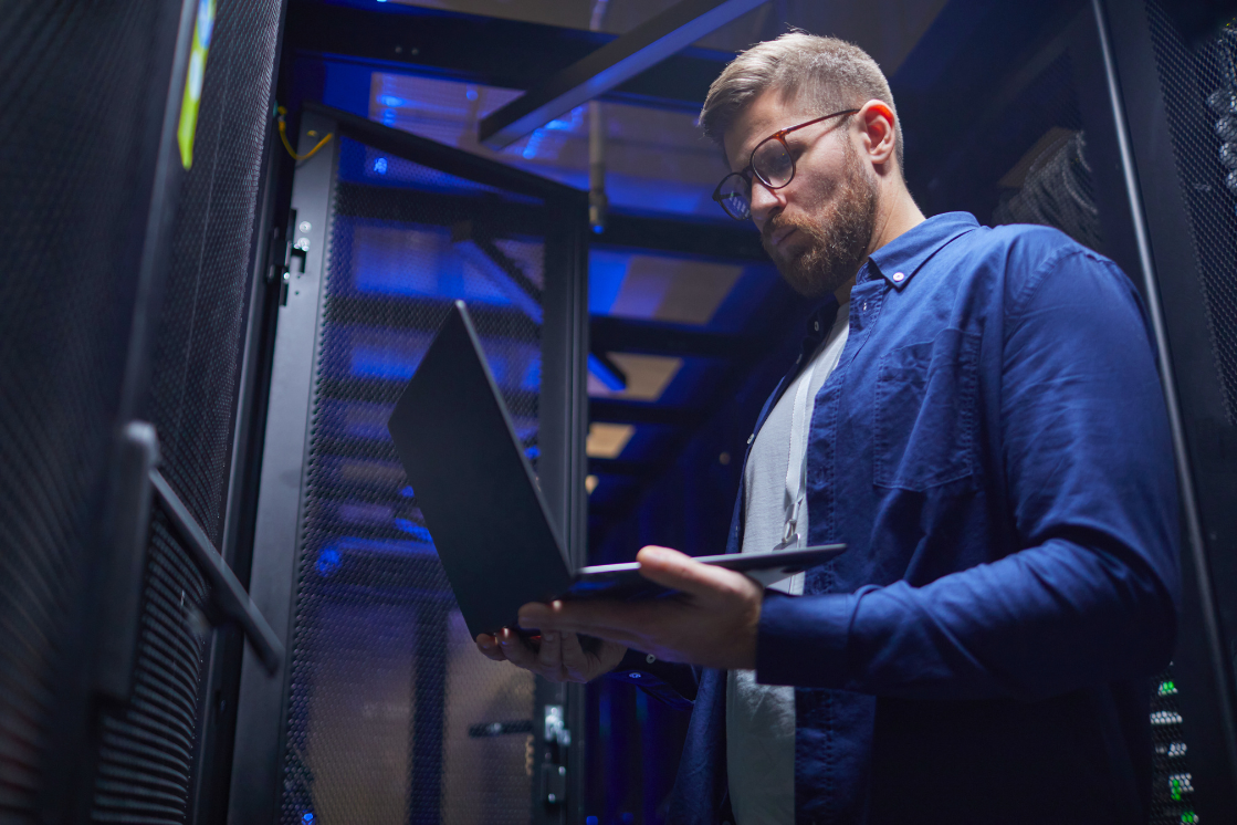 A technician works in the server room managing assets.