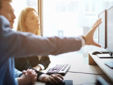 Collaborate is pivotal in business and these coworkers are reviewing information on a monitor.