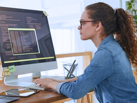 IT professional sits at her desk working on a short term project.