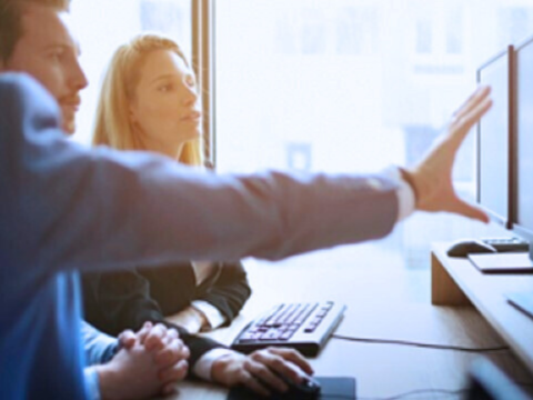 A team reviews information on a monitor